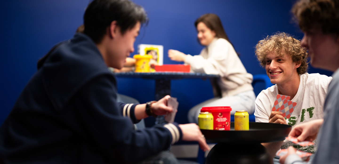 Boys playing cards in the games room at Scape Leicester