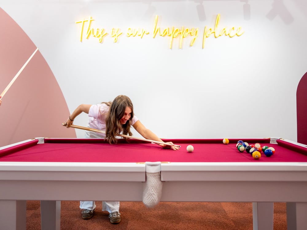 Resident playing pool in common area at Scape Ascot student accommodation.
