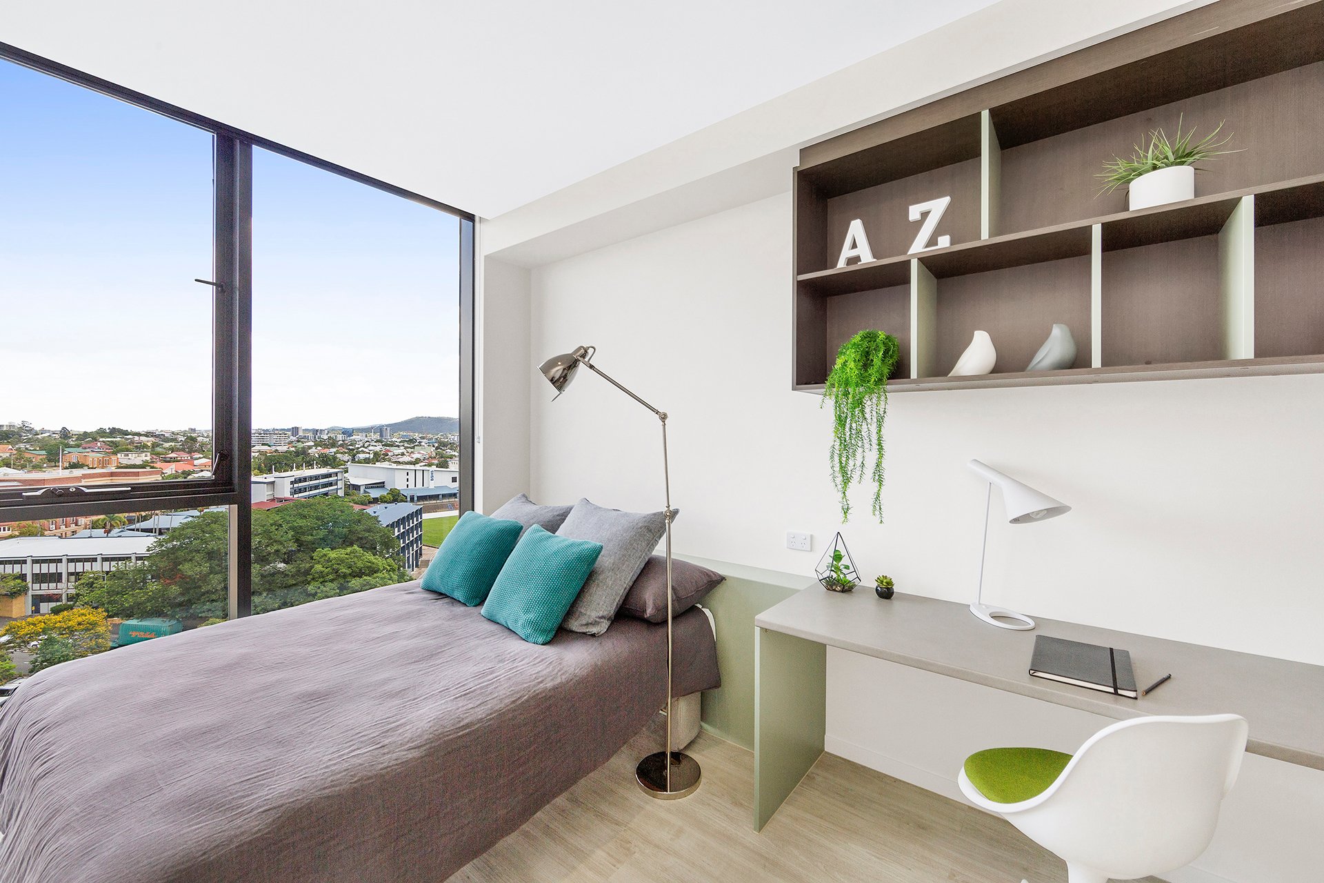 Bed and desk in the large studio apartment