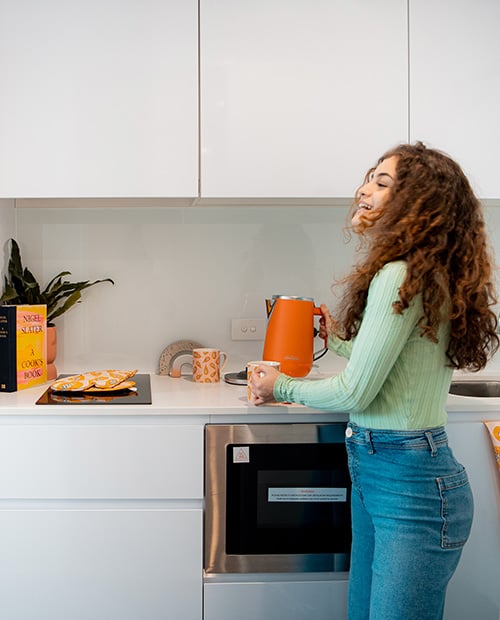 resident in student kitchen at Scape Redfern